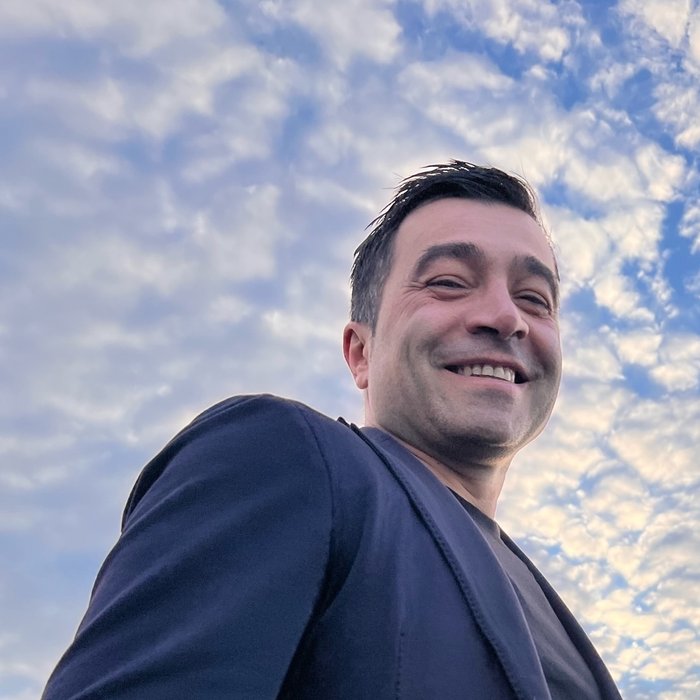 Francesco Tamburriello, smiling, outdoors under a bright sky